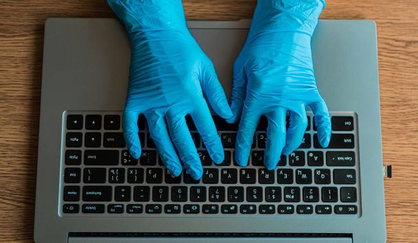 Tıbbi eldivendeki doktorun elleri laboratuardaki bir bilgisayarda analiz sonuçlarına ulaşıyor. Üst görünüm - Fotoğraf, Görsel