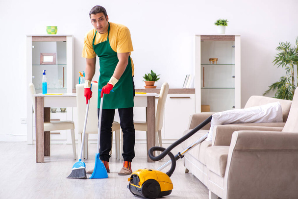 Fiatal férfi vállalkozó takarítja a házat - Fotó, kép