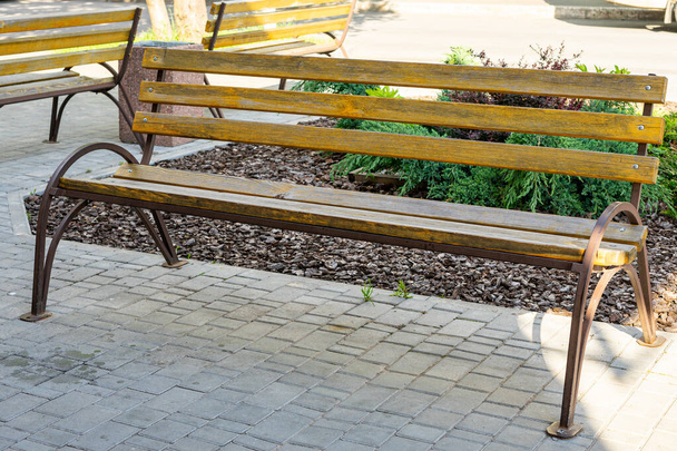 деревянная скамейка с металлической рамой в городе
 - Фото, изображение