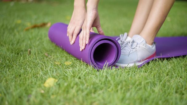 Woman is workout in outdoor with exercise mat - Foto, Imagen