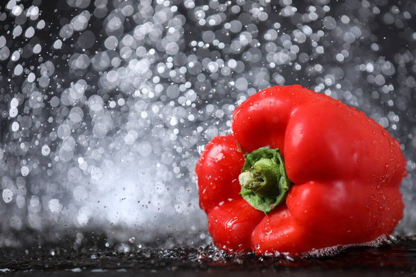 Horizontal view of red sweet paprika under the water drops in a black background. Healthy lifestyle. - Photo, Image