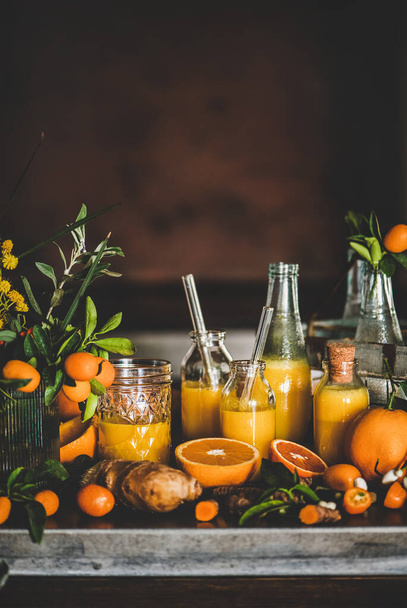 Immune boosting vitamin health defending drink. Turmeric, ginger and citrus juice shots in bottles and fresh plant ingredients over kitchen counter, copy space. Pure vegan Immunity booster - Foto, Bild