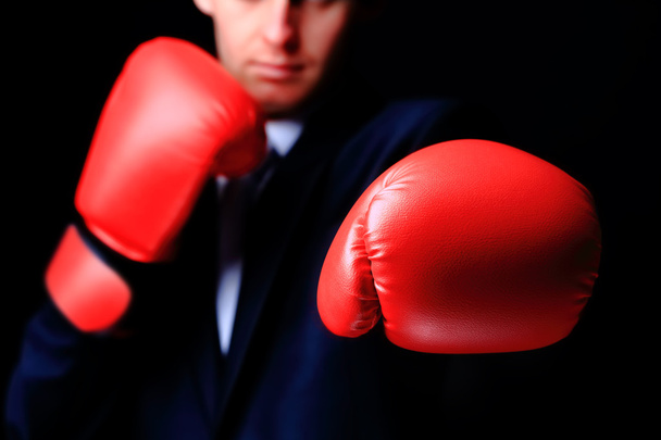 Businessman in boxing gloves isolated on black - Фото, изображение