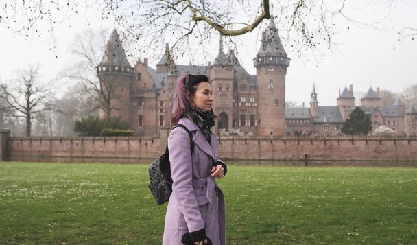 Vrouw wandelt rond kasteel De Haar bij Utrecht. Een belangrijke toeristische attractie in Nederland - Foto, afbeelding