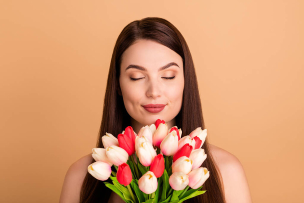 Close up photo of dreamy positive girlish lady hold blooming flowers 8-march celebration spring holidays after gift spa salon aesthetic collagen procedure isolated over pastel color background - Photo, image