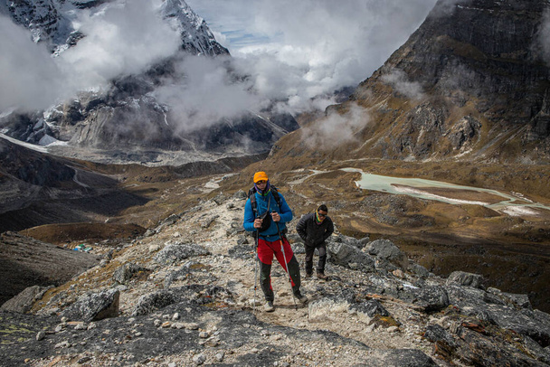 two tourists on the mountain trail in the Himalayas - Photo, Image