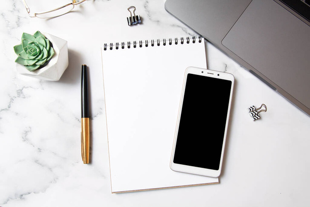 Piano di lavoro vista con un notebook mock-up, smartphone, laptop su uno sfondo di marmo. Concetto di business desktop - Foto, immagini