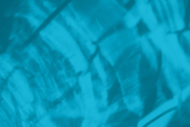 Trendy mintblauw gekleurde laag contrast abstracte achtergrond met licht en schaduwen bijtende effect. Licht gaat door een glas. Water achtergrond. 2021 jaar kleur trend - Foto, afbeelding