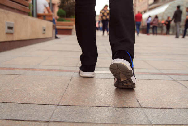 Close up of feet walking on the sidewalk.  - Foto, imagen