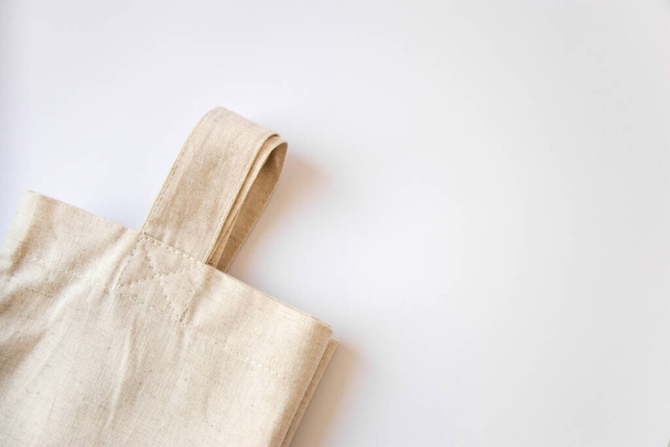 Öko-Baumwolltasche. Beige Tasche aus Naturmaterial auf weißem Hintergrund mit Kopierraum - Foto, Bild
