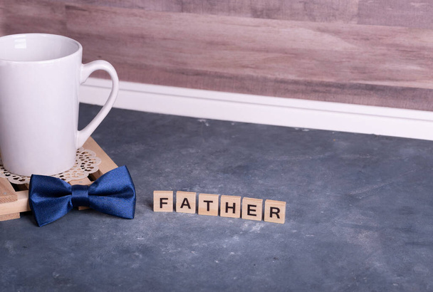 Men's accessory gift for Father's Day or anniversary on wood table background, Bow tie and coffee cup. - Foto, Bild