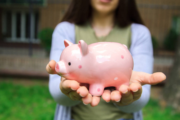 A woman hands holding a pink piggy bank - Photo, Image