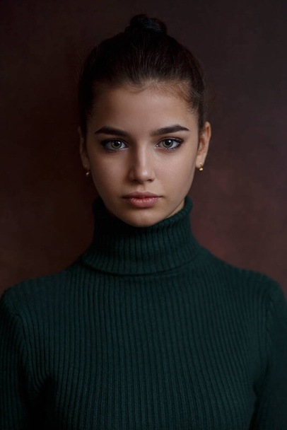a girl in a green sweater and skirt on a dark background - Foto, Imagem