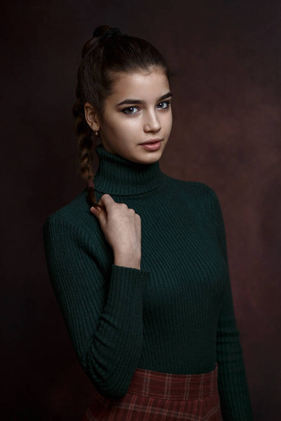 a girl in a green sweater and skirt on a dark background - Fotografie, Obrázek