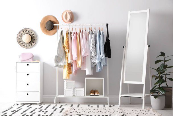 Rack with stylish women's clothes and mirror indoors. Interior design - Foto, Imagem
