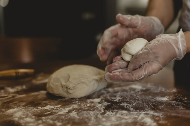 Hands of a woman making dough with plastic gloves on the table in Turkey - Foto, immagini
