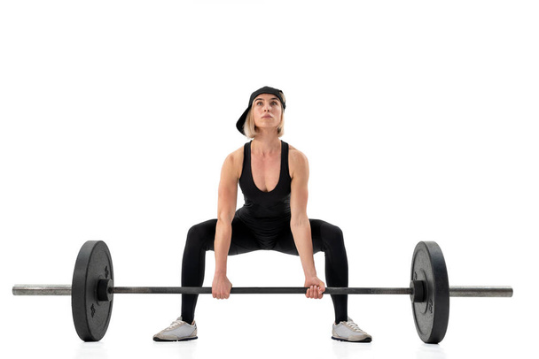 Young woman doing deadlift with a barbell isolated on white - Foto, immagini