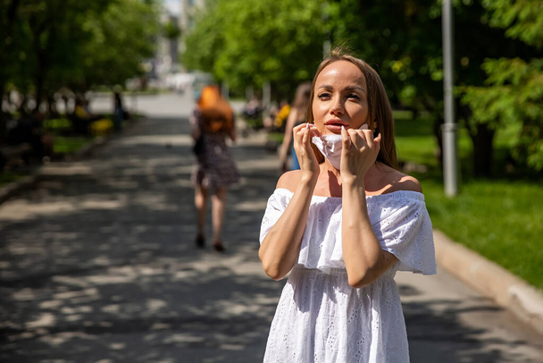 girl in the park takes off a medical mask - Фото, зображення