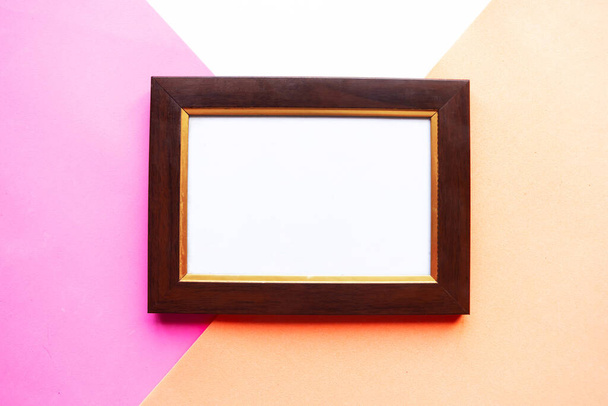Wooden photo frame on geometric pink and white background. Copy space for the text - Foto, Imagem