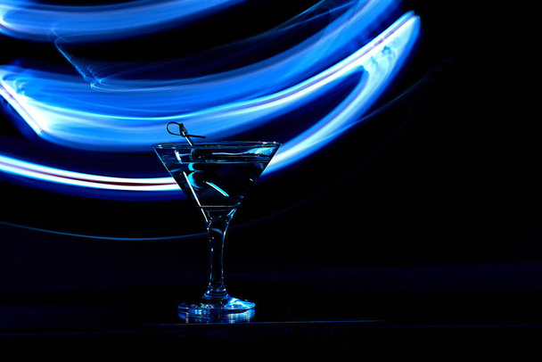 Martini cocktail drink splash with ice cubes in neon iridescent . Minimal night party life concept. - Foto, Imagen