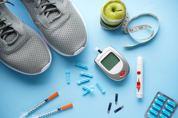 Sports diabetic. Digital glucometer. Concept of a healthy diabetic on blue background. Flat lay. - Photo, Image