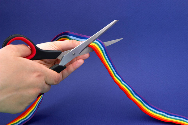 Prohibition of demonstrations and same-sex marriage. The LGBT rainbow ribbon tape is cut with scissors. - Φωτογραφία, εικόνα