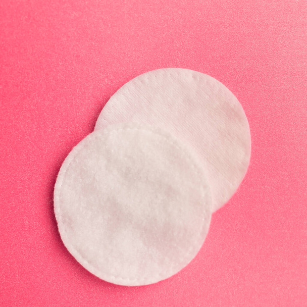 Cotton sticks and pads on a pink background, space for text - Foto, afbeelding