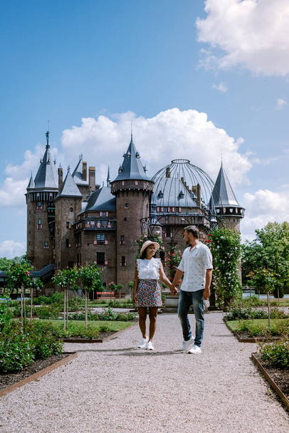 antigo castelo histórico jardim, Castelo de Haar Holanda Utrecht em um dia de verão brilhante, jovem casal homens e mulher de meia idade andando no jardim do castelo
 - Foto, Imagem