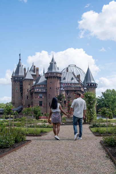 歴史ある古城庭園、オランダ城館夏の明るい日には、若い夫婦と中世の女性が城庭園を歩いています - 写真・画像