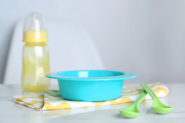 Set of plastic dishware on white table indoors. Serving baby food - Zdjęcie, obraz