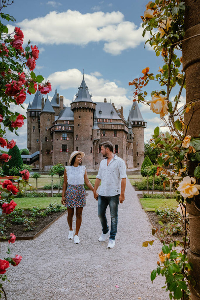alter historischer Burggarten, Schloss de Haar Niederlande Utrecht an einem hellen Sommertag, junges Paar Männer und Frauen mittleren Alters spazieren im Burggarten - Foto, Bild