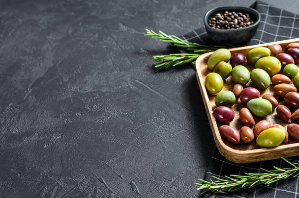 Mélange d'olives marinées colorées avec un os. Fond noir. Vue de dessus. Espace pour le texte
. - Photo, image