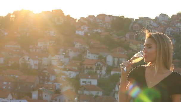 Aantrekkelijk vrouwelijk Blond Model Drinking Champagne op het dak, zonlicht achtergrondverlichting - Video