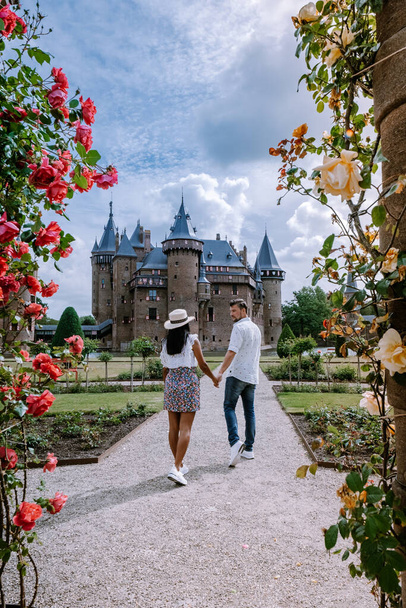 oude historische kasteeltuin, Kasteel de Haar Nederland Utrecht op een heldere zomerdag, jong stel mannen en vrouw van middelbare leeftijd wandelend in de kasteeltuin - Foto, afbeelding