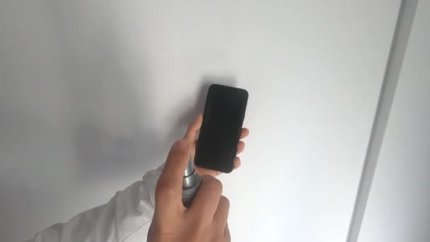 mujer limpiando su celular con alcohol para la prevención
 - Metraje, vídeo