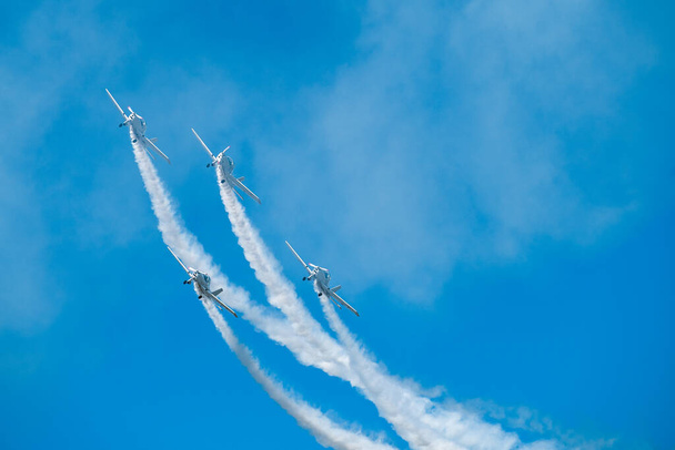 Lentokoneet, joissa on valkoista savua ilmassa. Lentäjät tekevät temppuja suihkukoneita sininen taivas tausta
 - Valokuva, kuva