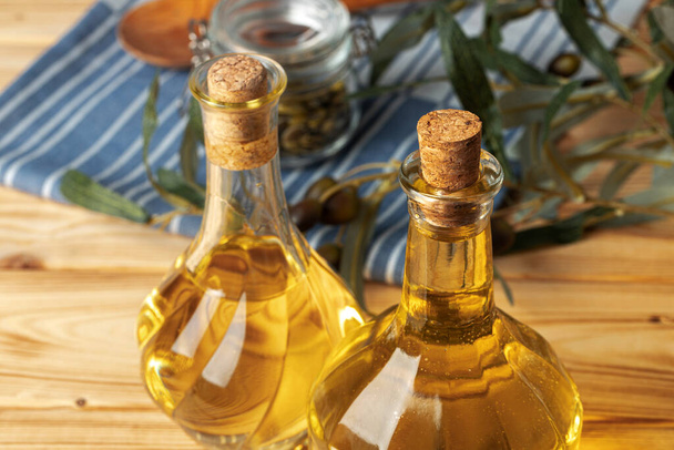 Olive oil bottle on wooden table, close up. - Photo, image