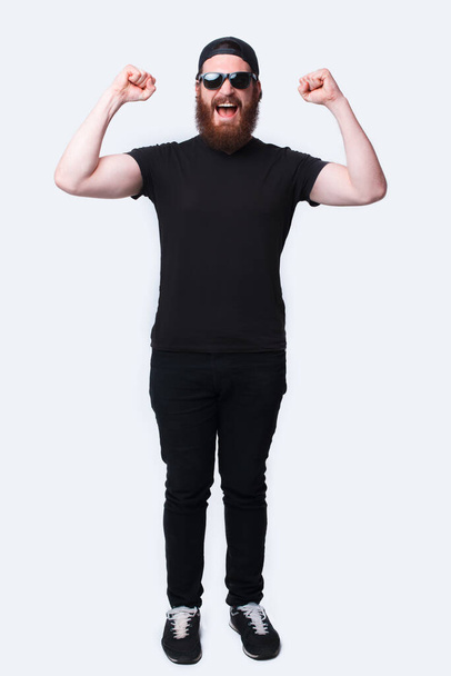 Фотографія на повну довжину вражена бородатим чоловіком, який святкує перемогу над білим
 - Фото, зображення