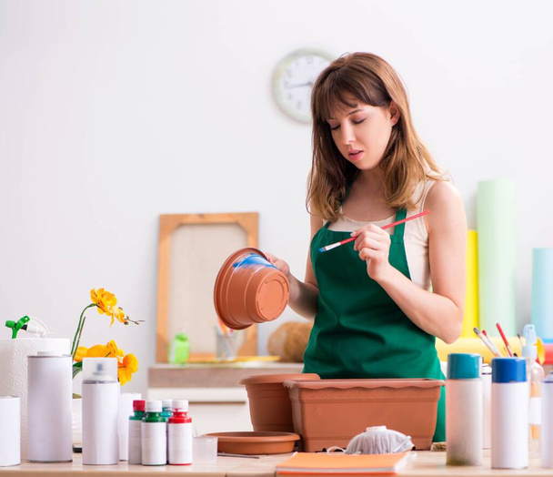 Молода жінка прикрашає кераміку в майстерні
 - Фото, зображення