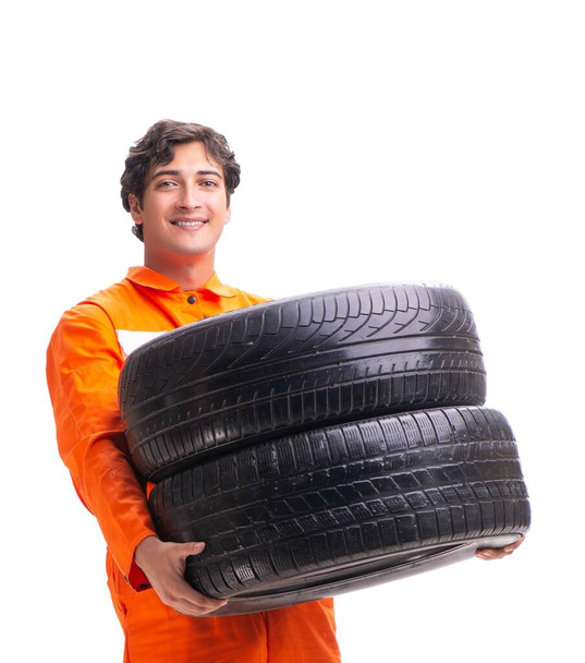Молодий працівник гаража з шиною ізольовано на білому
 - Фото, зображення