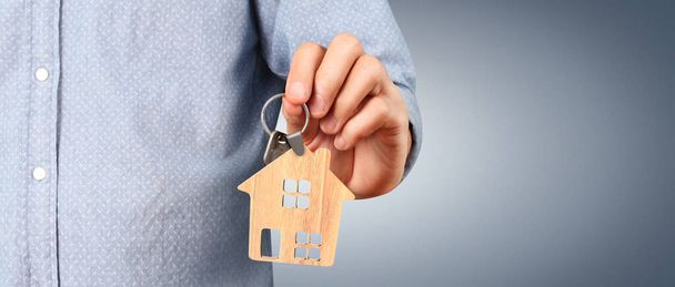 Μεσίτης ακινήτων παραδίδει τα κλειδιά του σπιτιού σε ένα χέρι - Φωτογραφία, εικόνα