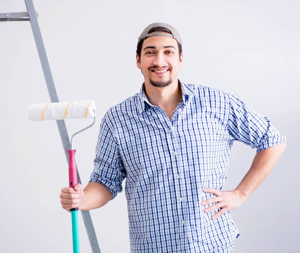 Молодой художник делает ремонт дома - Фото, изображение