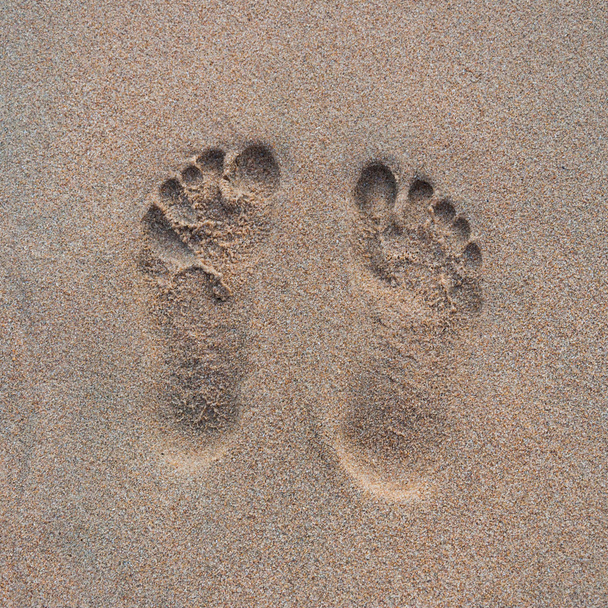 Dos huellas humanas en la arena de la playa
 - Foto, Imagen