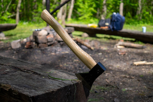 Chopper or ax stuck upright in a tree stump outdoors in a garden or woodland conceptual of an outdoor lifestyle or camping - Фото, изображение