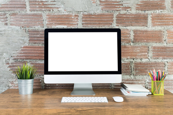 pracovní plocha s počítačem s prázdnou bílou obrazovkou a kancelářské potřeby na dřevěném stole - Fotografie, Obrázek