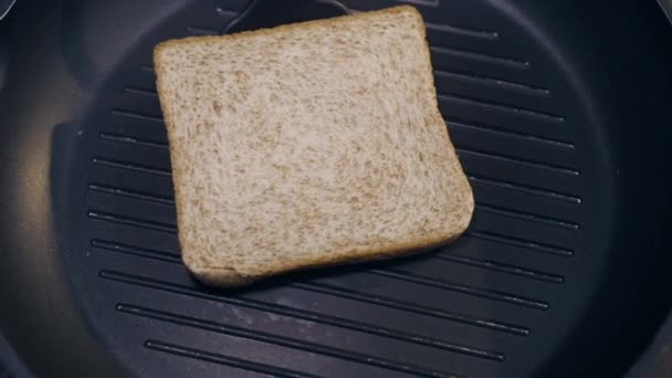 le cuisinier porte un toast d'un côté à l'autre sur la poêle chaude
 - Séquence, vidéo