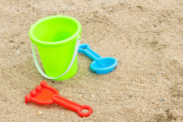 kleurrijke plastic speelgoed voor het strand op zand - Foto, afbeelding