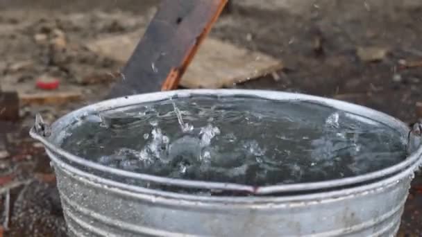 water dripping into a bucket. drops of water flow down from the roof after rain - Footage, Video