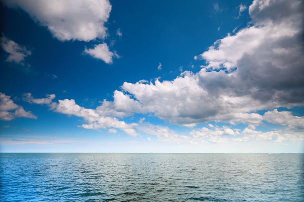Σύννεφο γαλάζιο ουρανό πάνω από μια επιφάνεια της θάλασσας - Φωτογραφία, εικόνα
