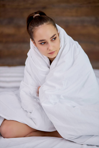 young girl is cold at home, she is wrapped in blanket - Фото, зображення